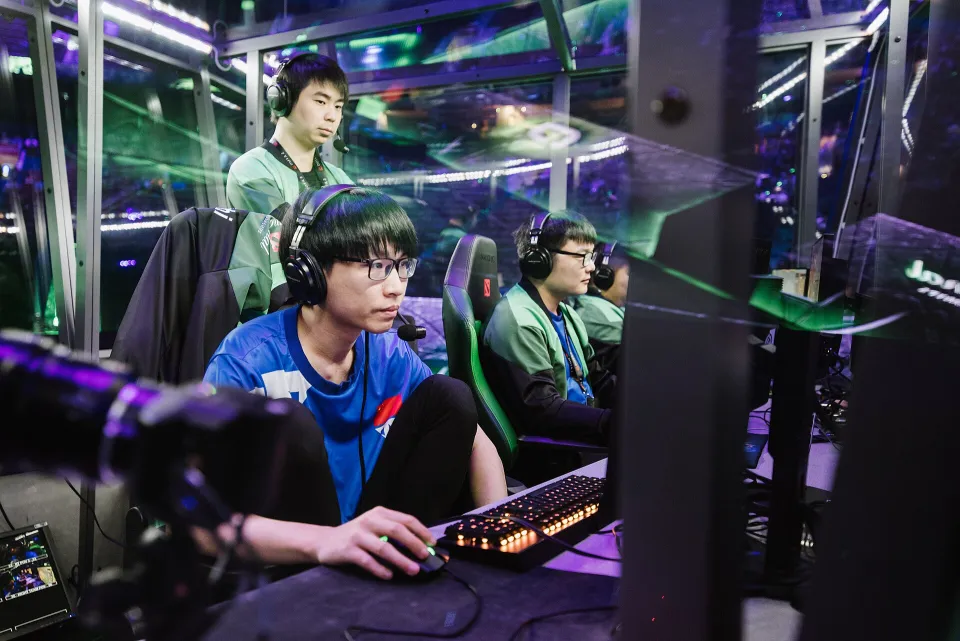 Jogadores em computadores dentro de uma cabine no palco do The International 2018
